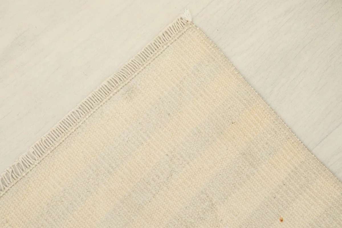 View of the reverse side of the hand-knotted wool rug, showing the cotton foundation