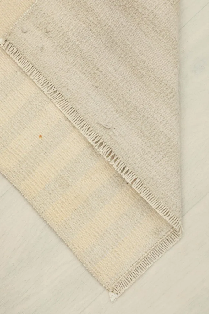 Folded corner of the rug, illustrating its flexibility and construction