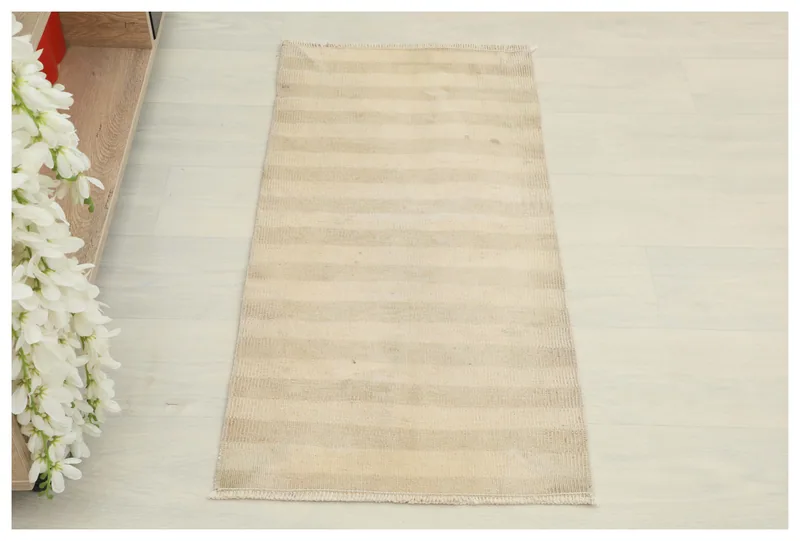 Full top view of the beige and tan striped vintage Anatolian doormat on a white background.