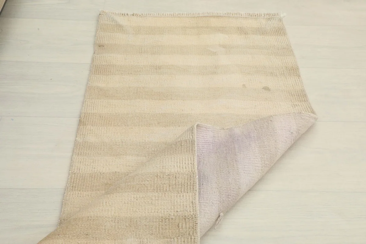 The rug partially folded, displaying both the front and back textures and the overall flexibility.