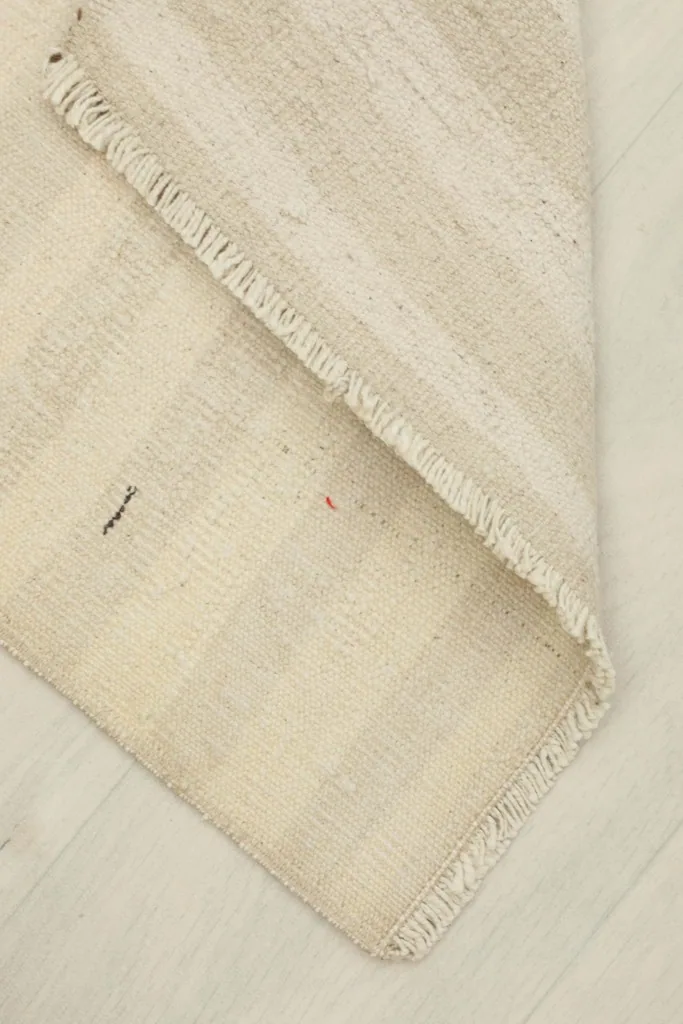 The rug partially folded to show its flexibility and thickness of the wool pile.