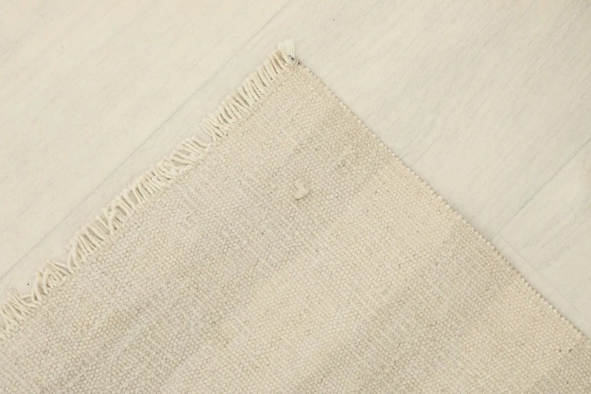 View of the back of the rug, revealing the cotton foundation and knotting