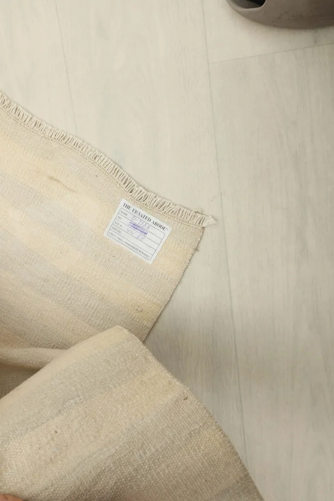 Detail of the rug's underside with a label, indicating its origin and materials