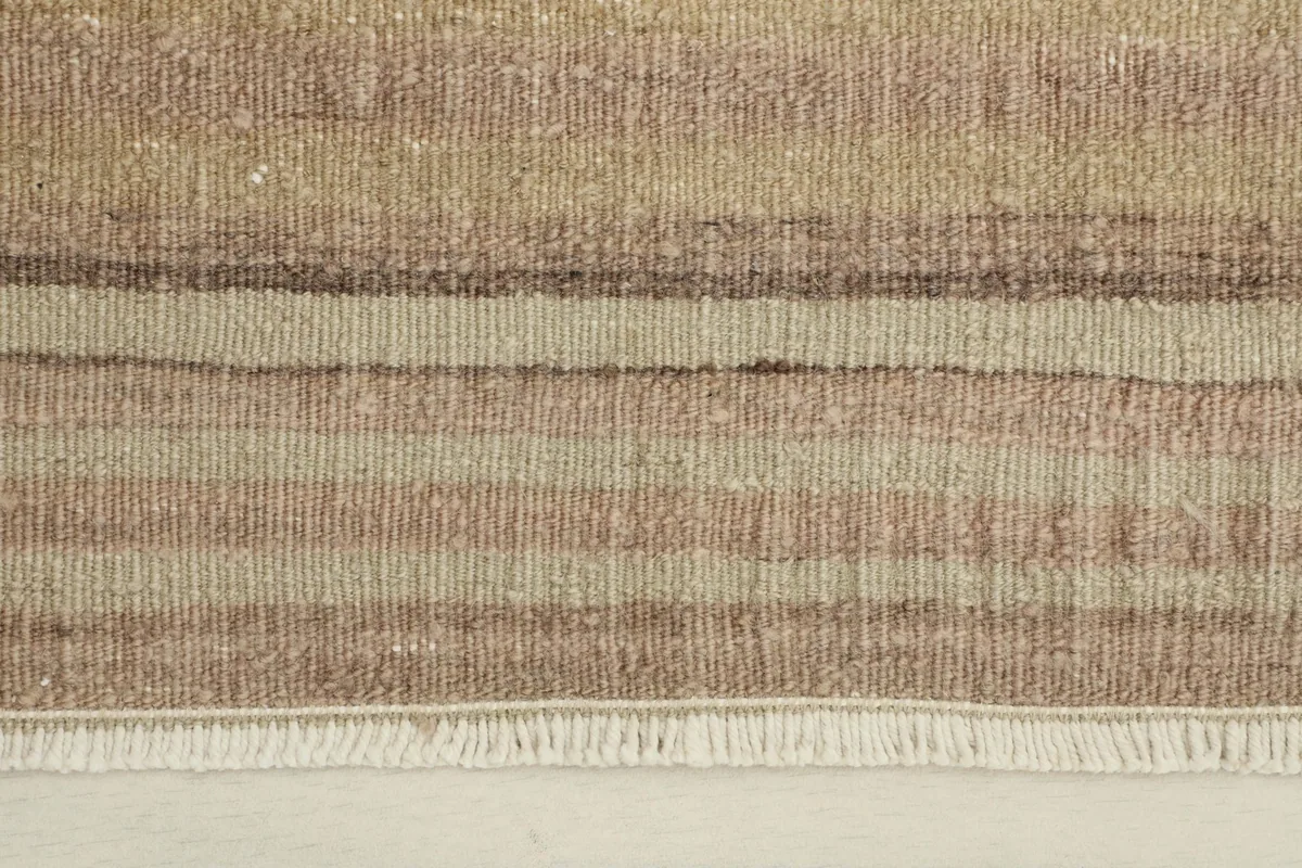 Close-up detail of the hand-knotted wool pile, showing the distinct beige, brown, and rose stripes.