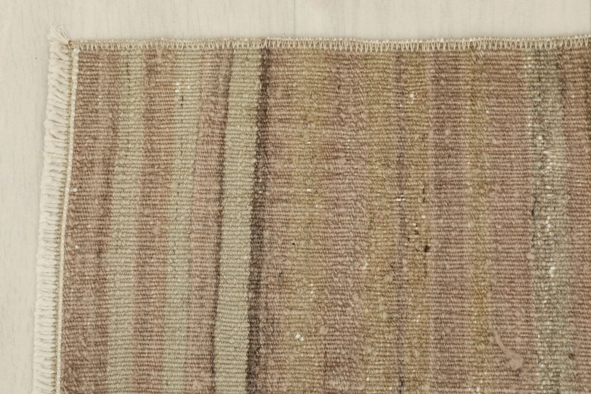Close-up of a corner, revealing the fringe and the tight weave of the rug's edge.