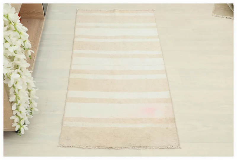 Full top view of the beige and cream striped vintage Anatolian wool doormat on a white background.