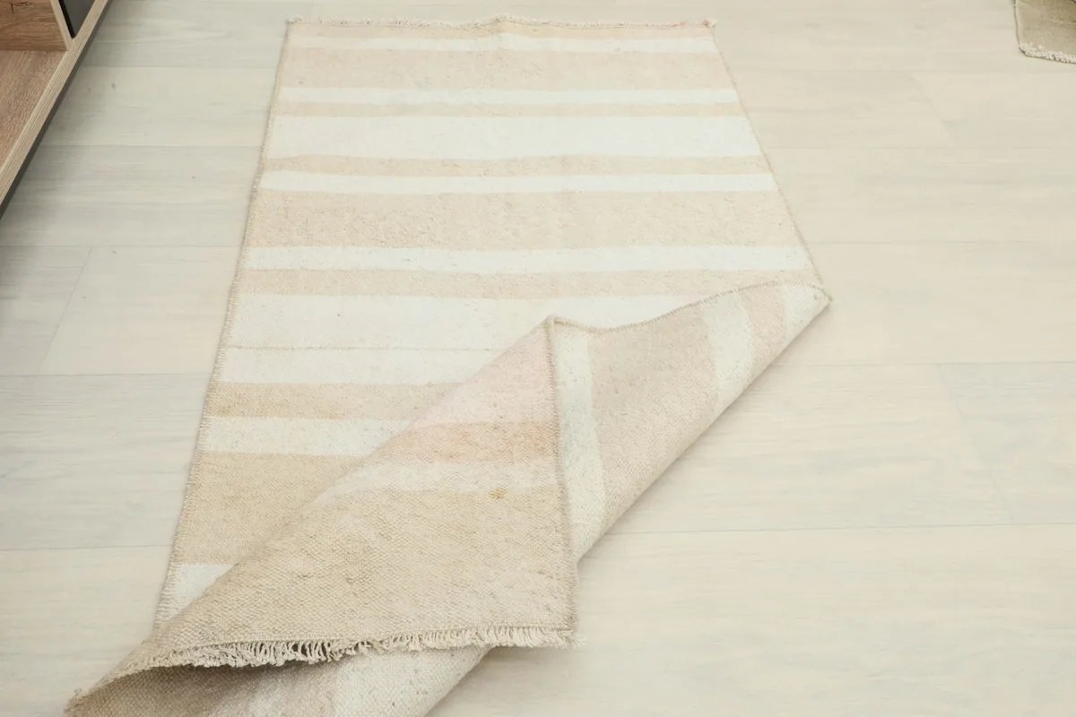 The doormat partially folded, showcasing its size and appearance in a spacious room environment.