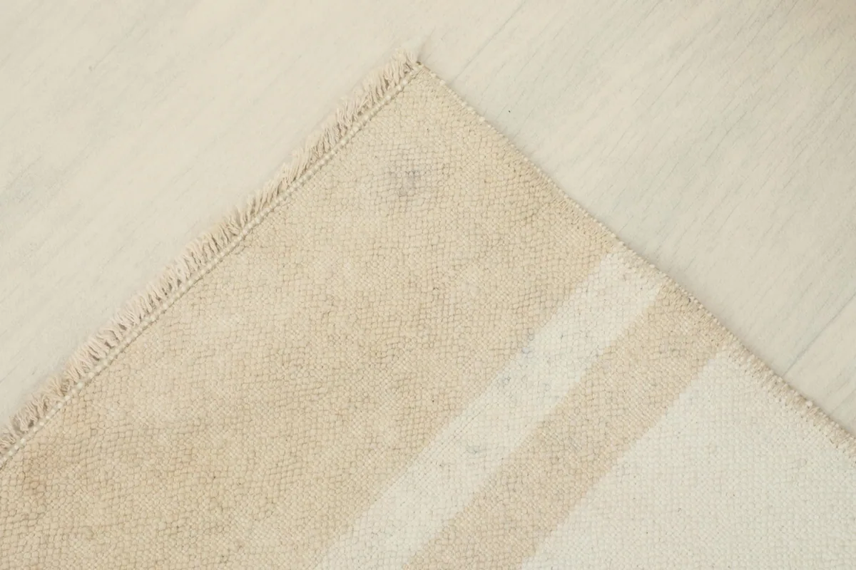 Corner view of the rug, detailing the edge finish and the consistency of the striped design.