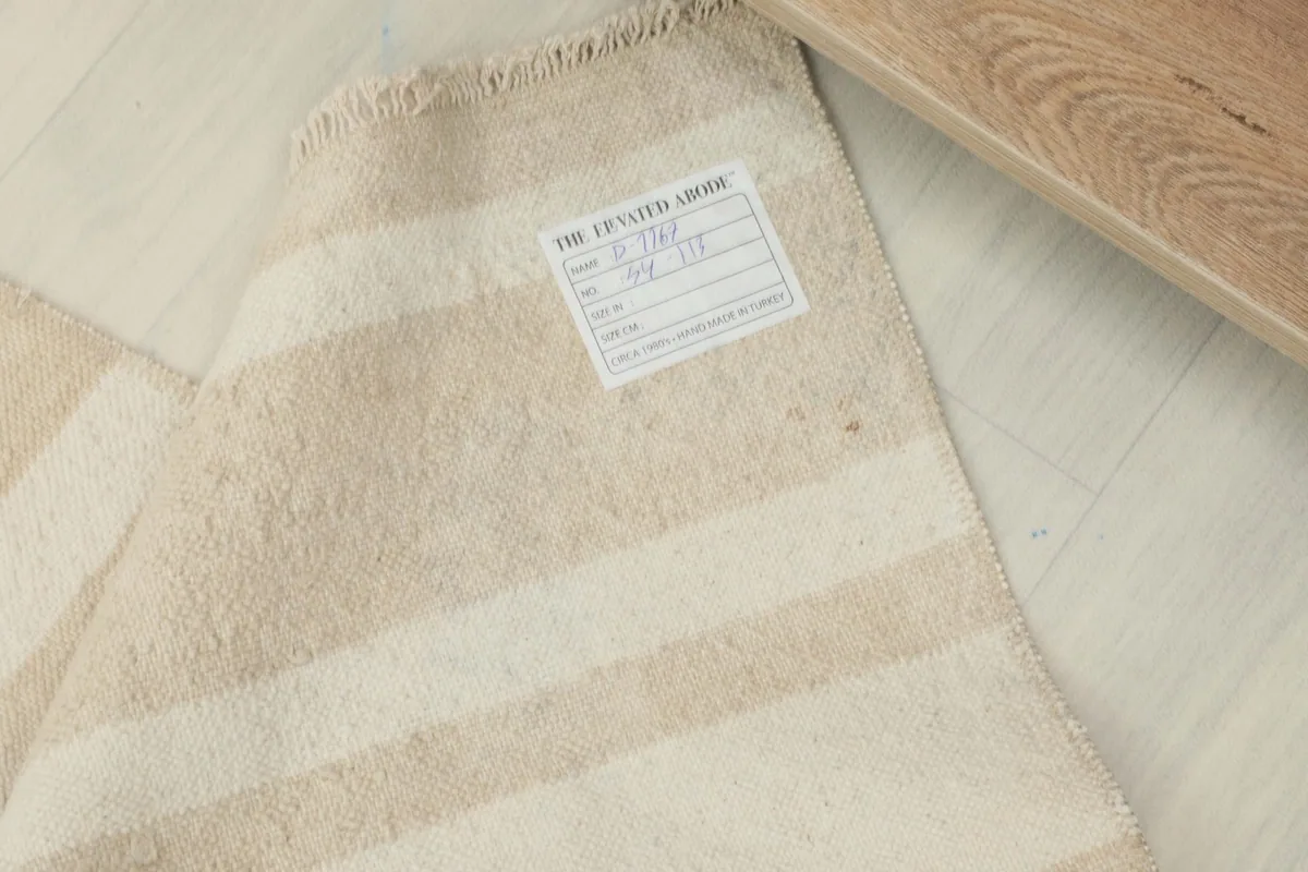 Close-up of the back of the rug, showing the hand-knotted construction and a product label.