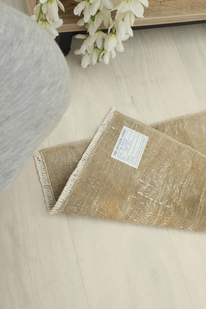 View of the back of the rug with its label, showing the tightly woven cotton foundation.