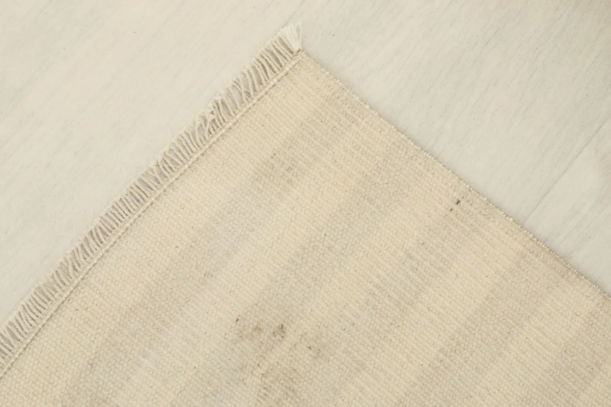 Underside view of the rug, revealing the cotton foundation and the hand-knotted construction.