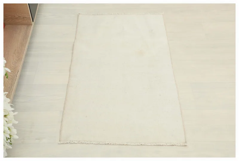 Full top view of the 1'8" x 3'1" ivory vintage Anatolian rug on a white background