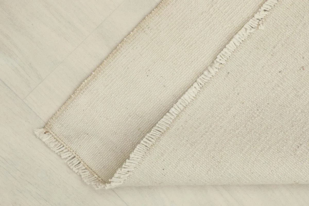 Partial view of the rug's back, showing the sturdy cotton foundation and tightly woven knots