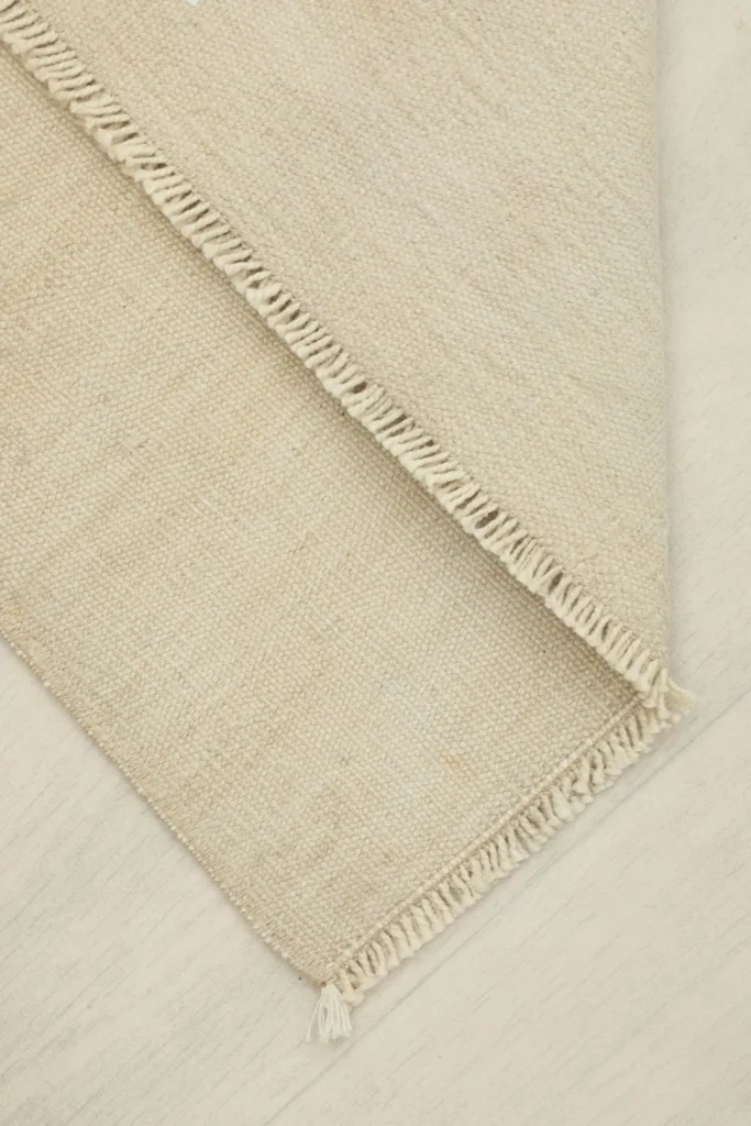 View of the rug folded to show its flexibility and the thickness of the wool pile.