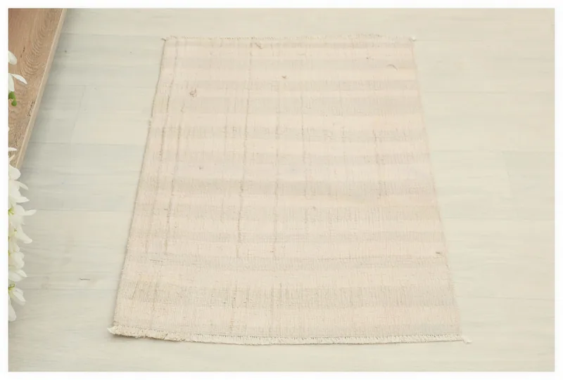 Full top view of the 1'7" x 2'5" ivory and beige striped vintage Anatolian rug on a white floor.