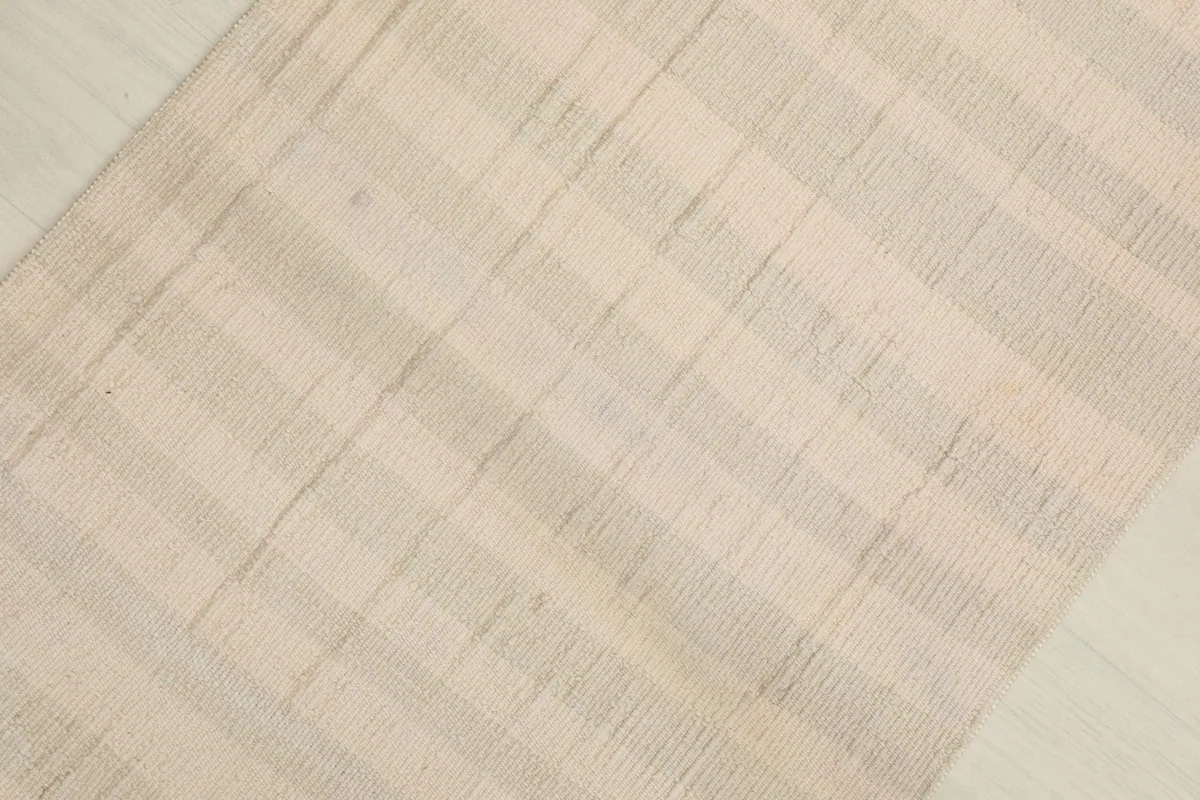 Detailed view highlighting the woven texture and light color variations of the vintage rug.
