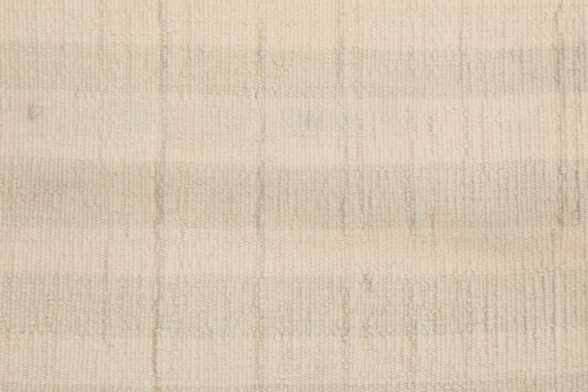 Close-up of the low wool pile, showing the tight knotting and the subtle striped pattern.