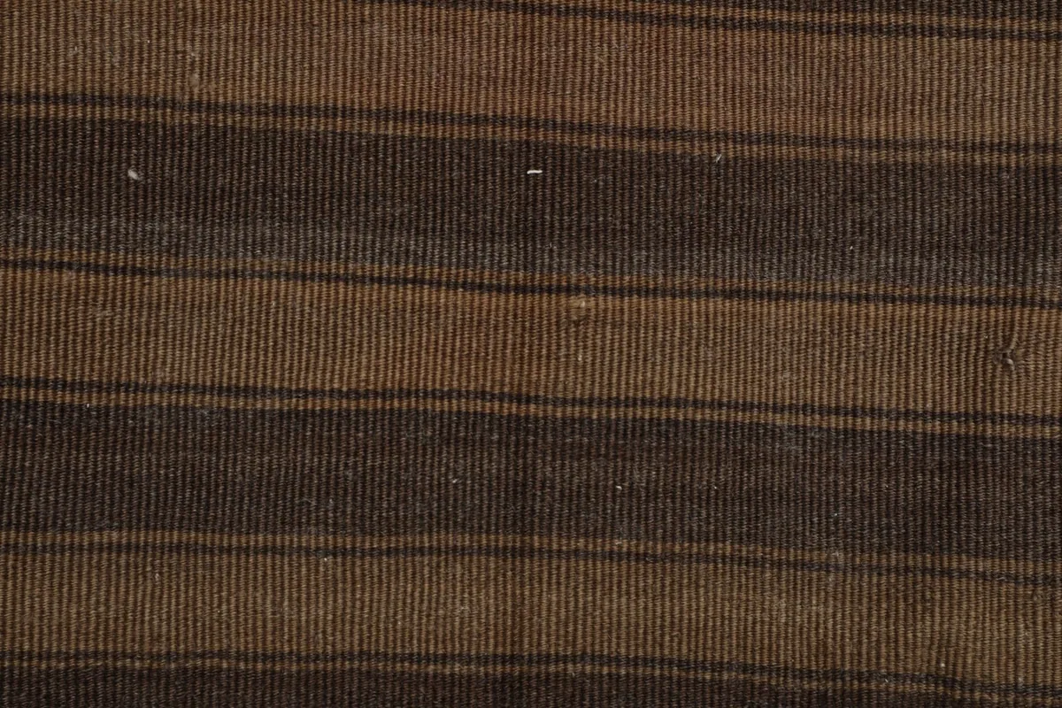 Detailed view of the low wool pile texture and hand-knotted construction of the striped rug