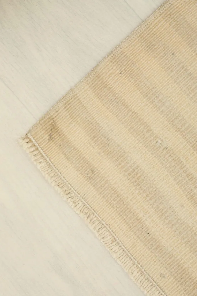 Angled view focusing on a corner of the rug, illustrating its natural drape and finish.