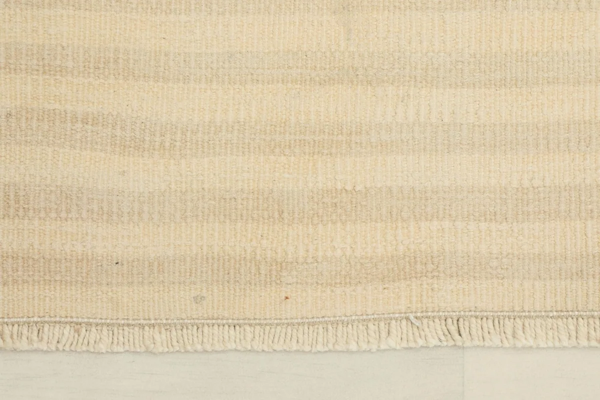 Close-up detail of the hand-knotted wool pile and the distinct beige and tan stripes.