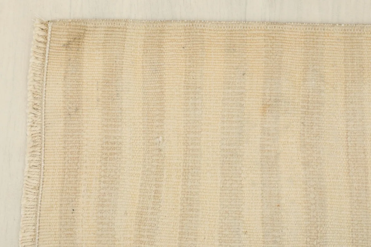 Corner detail of the rug, showing the clean edge and the short, natural fringe.