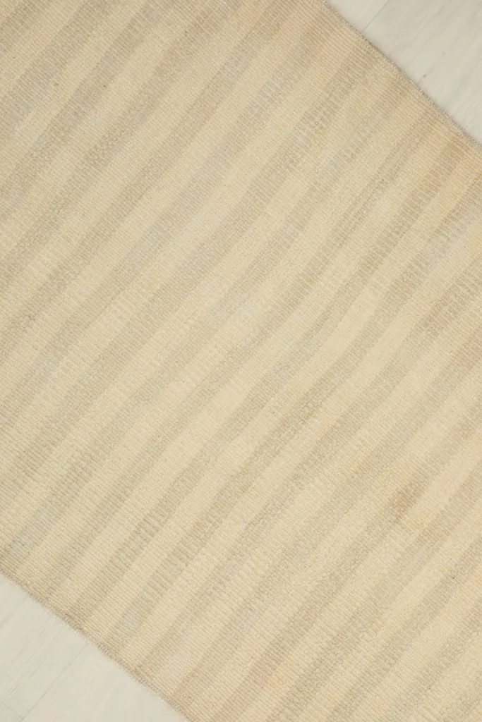 Overhead shot of the rug's surface, showing the subtle variations in the striped pattern and color.