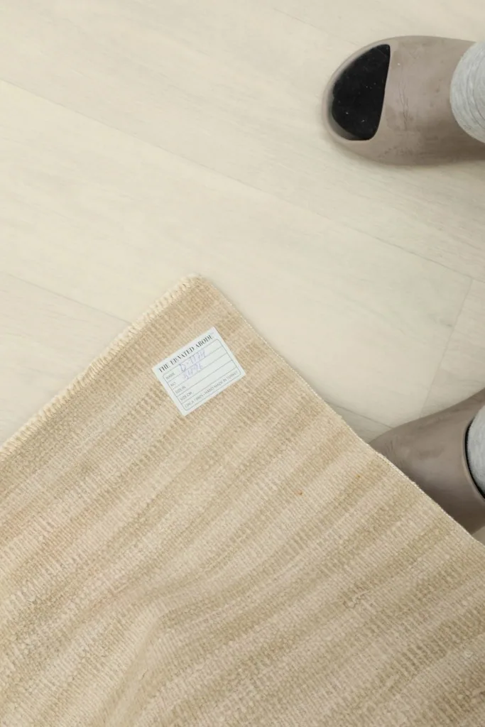 Corner of the rug with a tag, providing a sense of scale and the authentic vintage label.