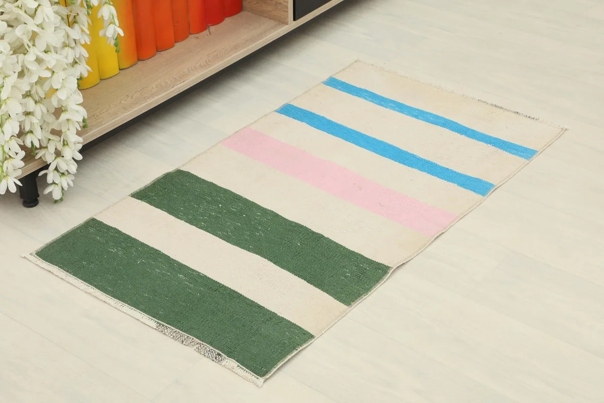 Vintage striped rug displayed in a room setting, showing its scale and vibrant colors.
