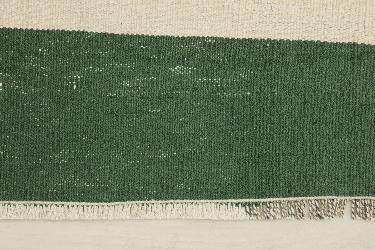 Close-up view of the green stripe, showing the wool pile texture and the fringe detail.