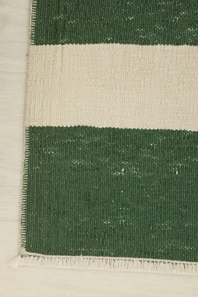 Corner detail of the rug, showing the finish of the edge and the short fringe.
