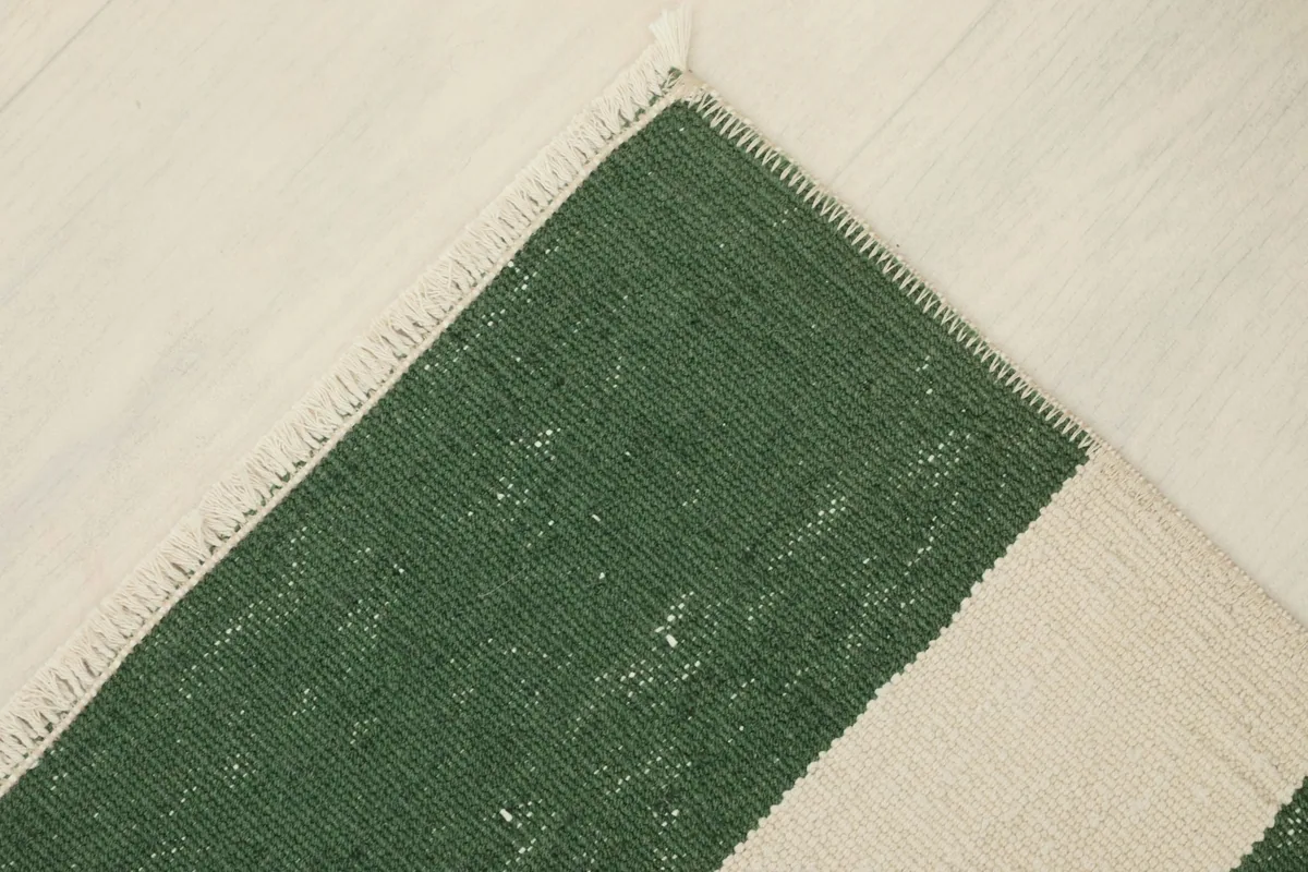 Partial view of the rug's reverse side, revealing the cotton foundation and knotting structure.