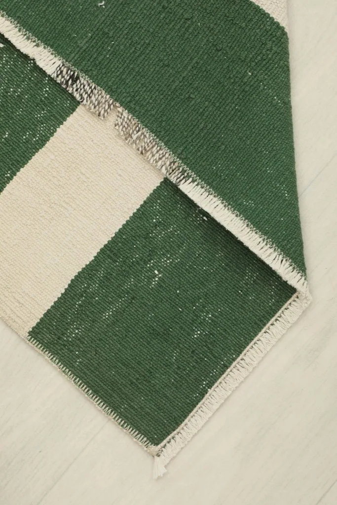 Rug folded to show the thickness and flexibility of the hand-knotted wool and cotton construction.