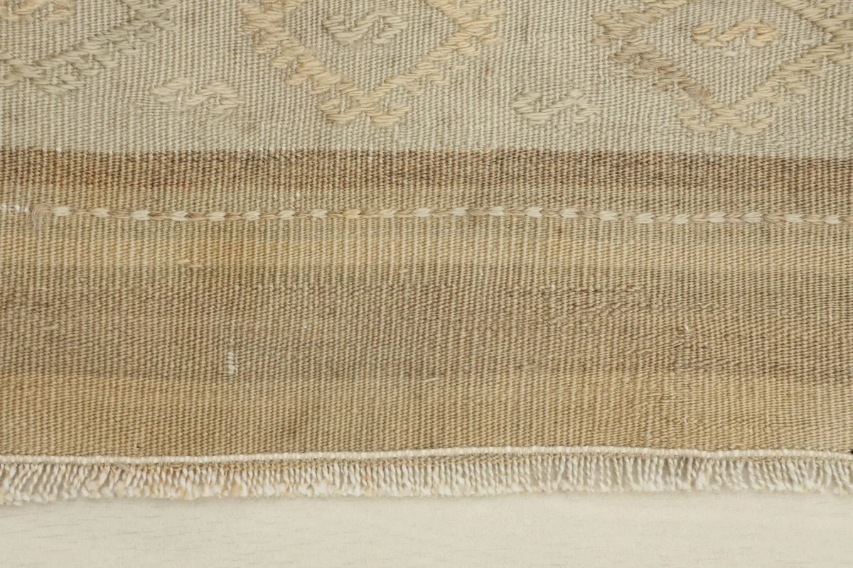 Close-up detail of the rug's hand-knotted wool pile and woven striped pattern.