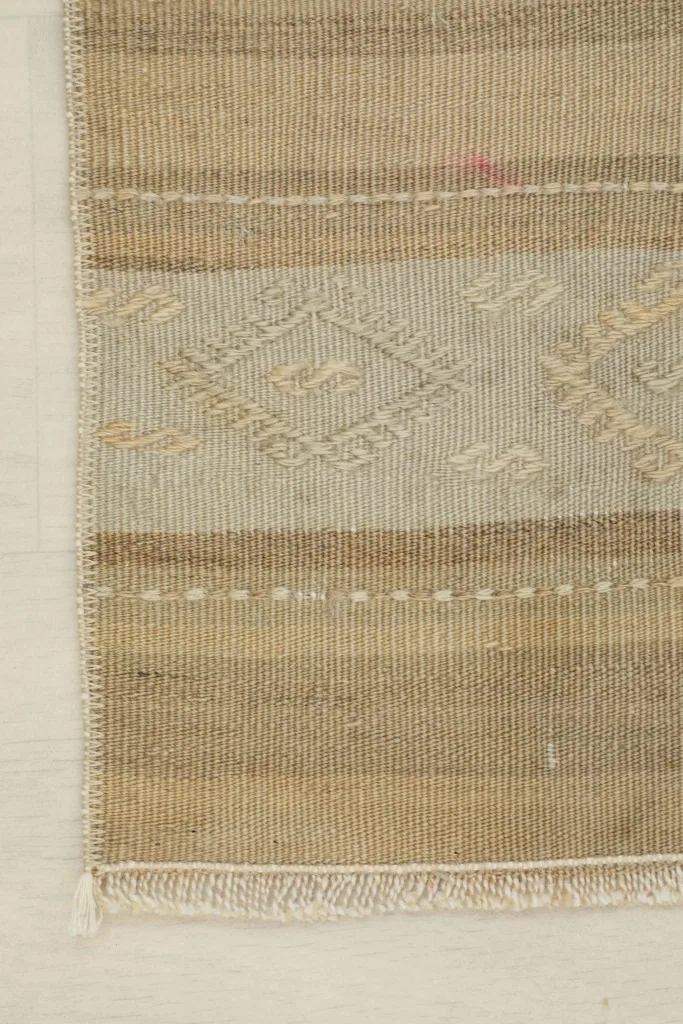 Close-up showing geometric motifs and subtle color variations within the beige and brown stripes.