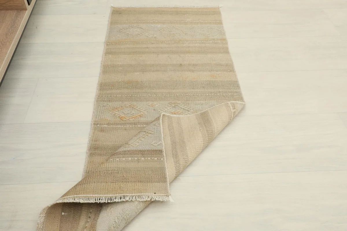 Angled view of the runner rug partially folded, showing its flexibility and full length.