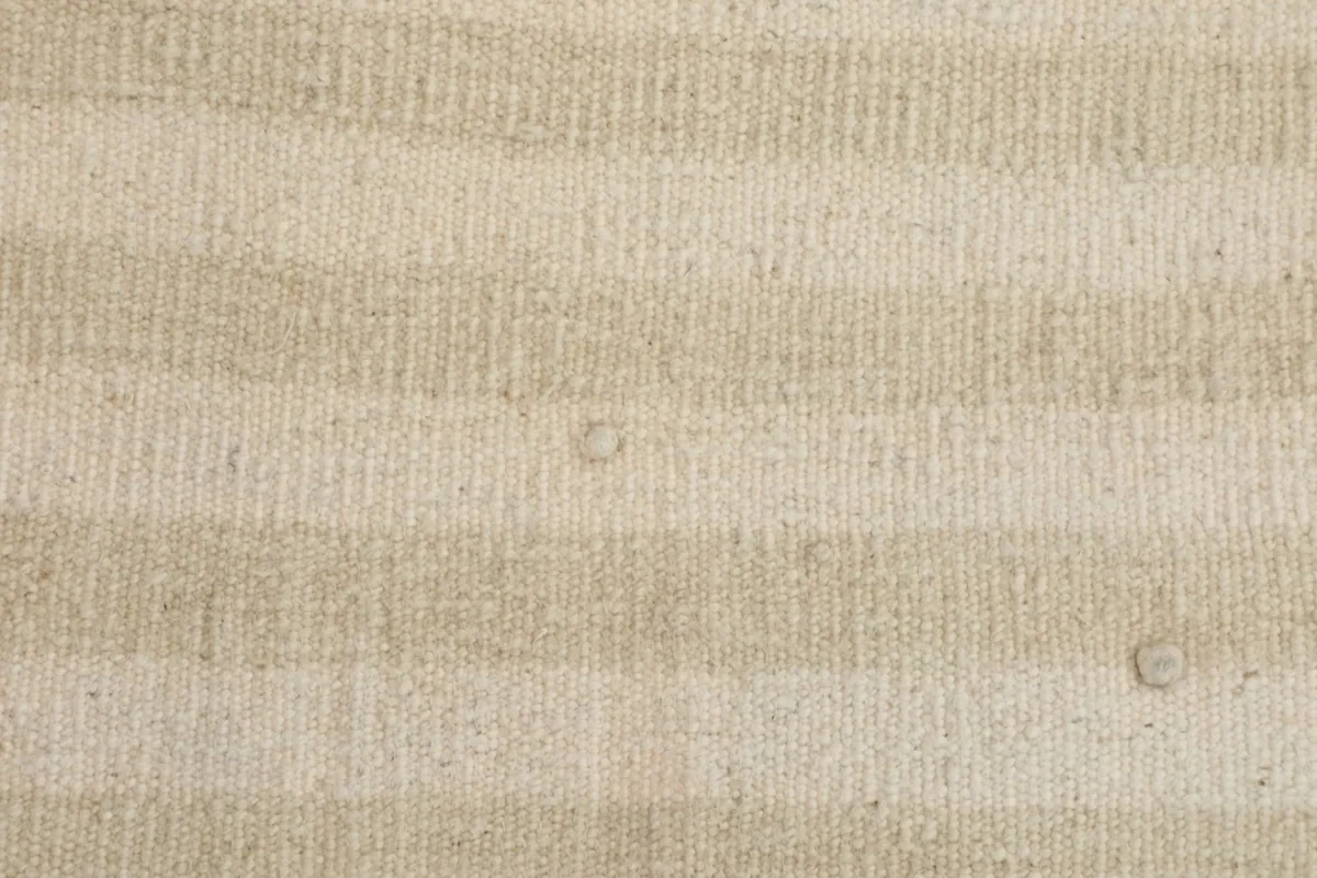 Close-up detail of the wool pile and woven texture of the striped rug.