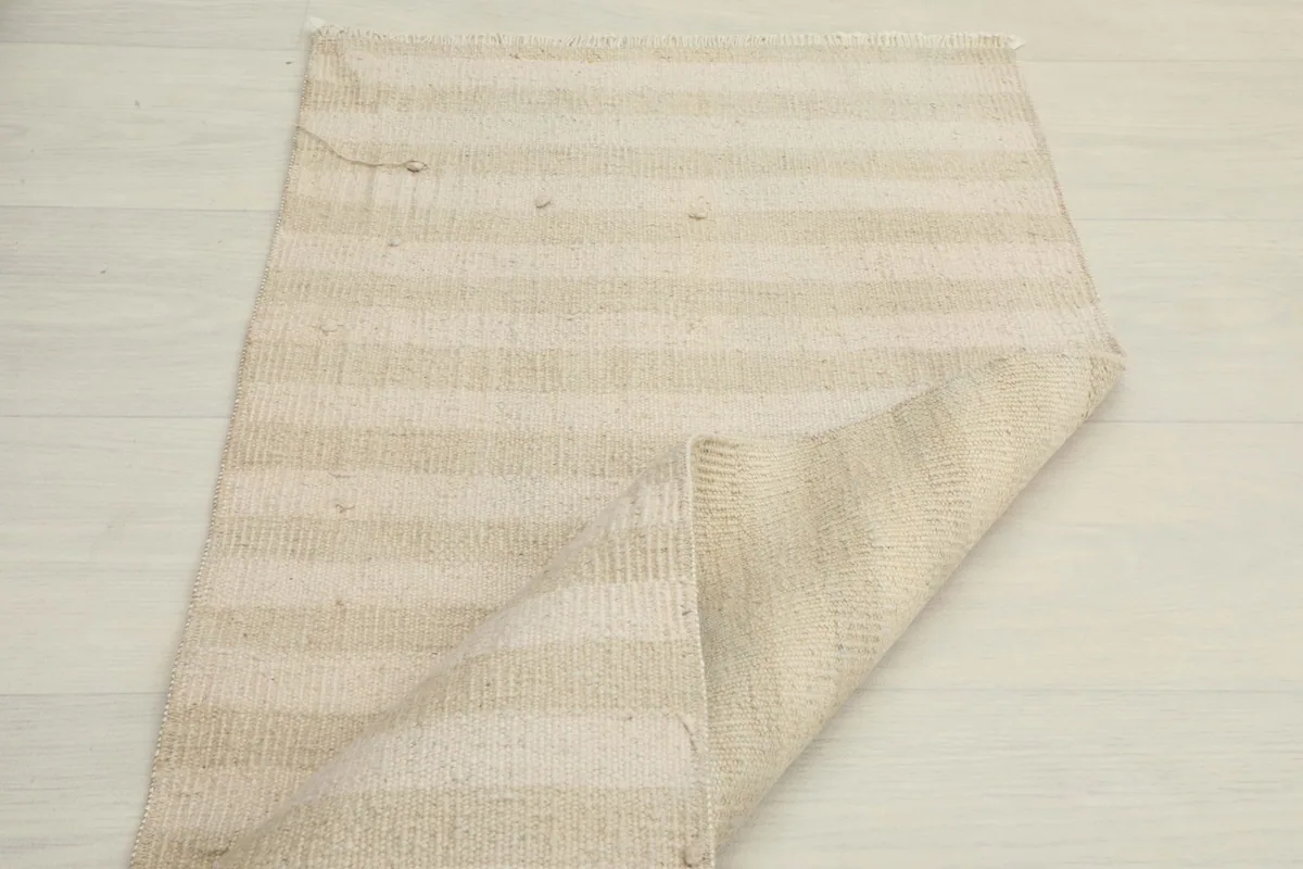 Rug partially folded, showcasing the full striped design and its flexibility.