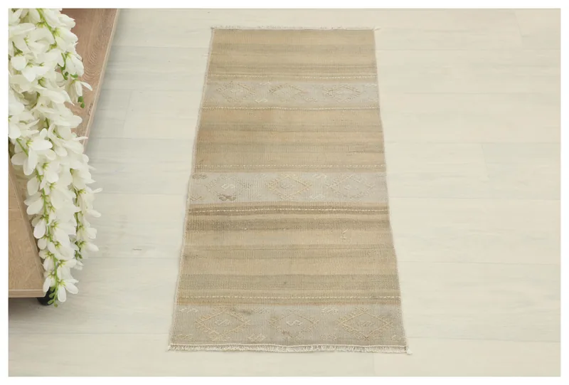 Full overhead view of the beige and tan striped vintage Anatolian doormat