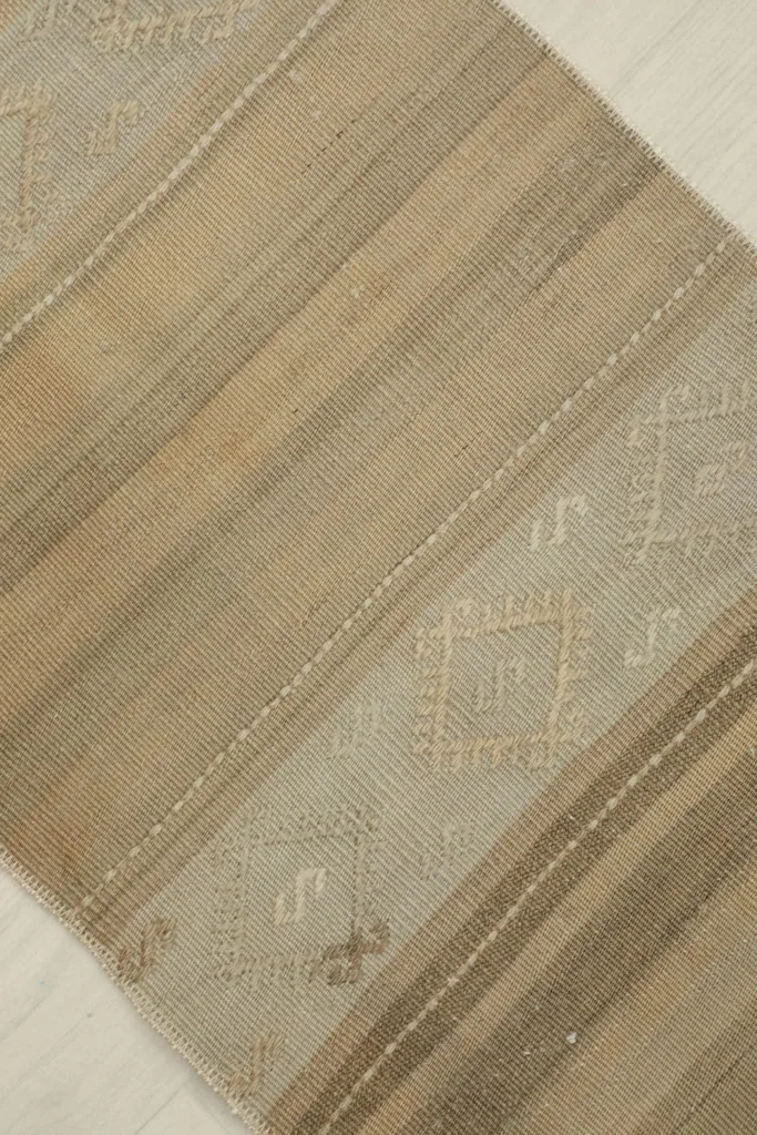 Diagonal view of the rug, emphasizing the varied beige and tan stripes