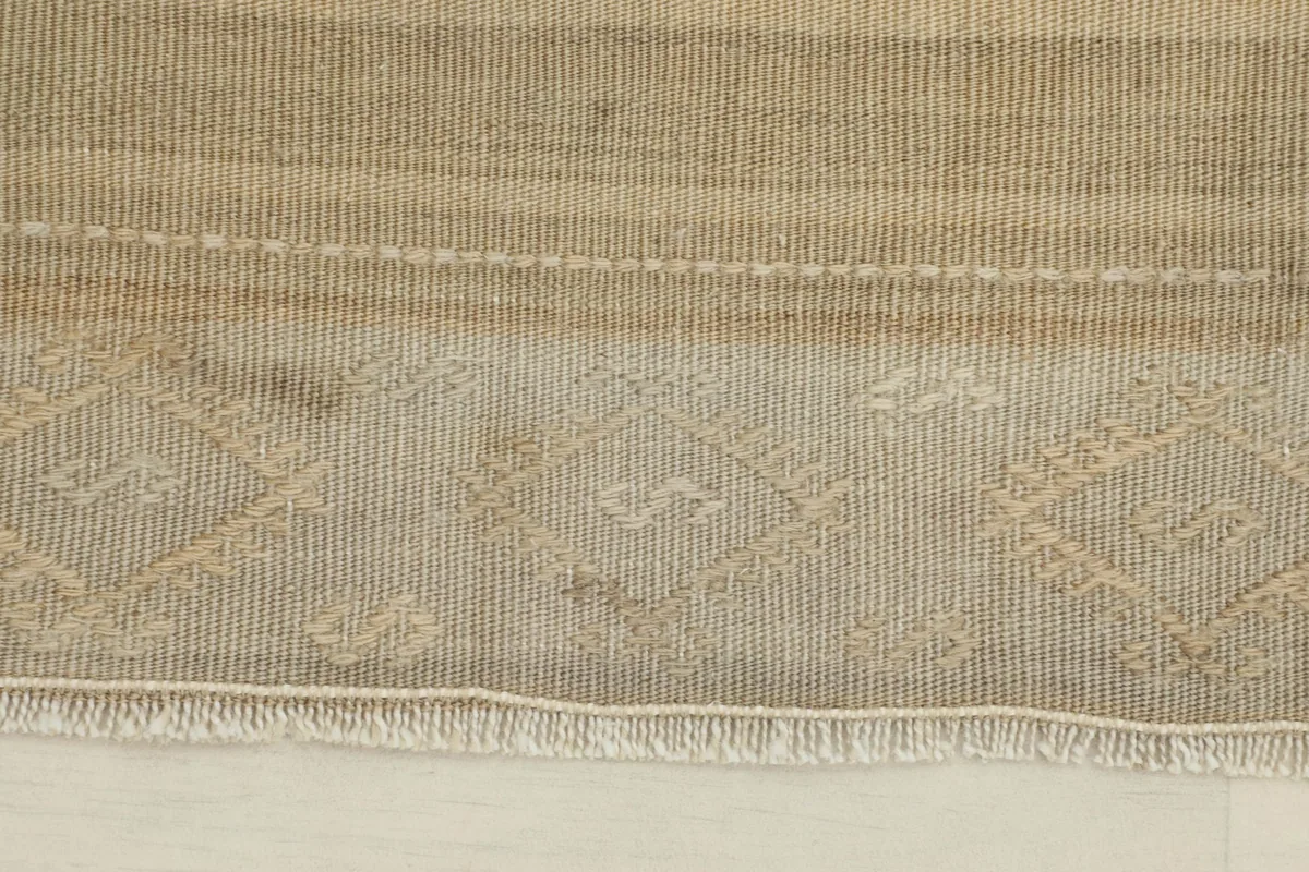 Close-up detail of the hand-knotted wool pile and subtle geometric patterns