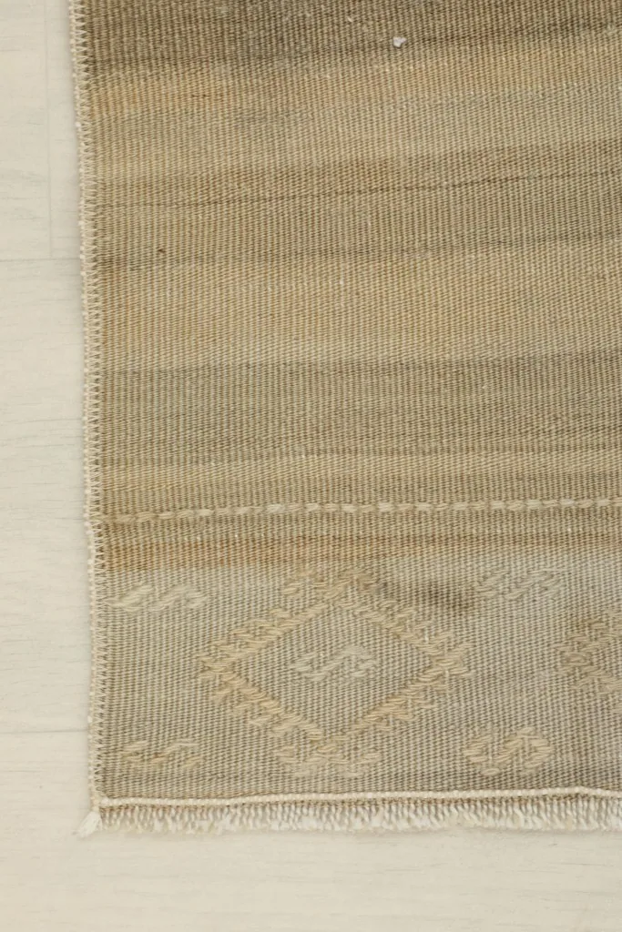 Corner detail of the rug, showing the striped texture and fringe