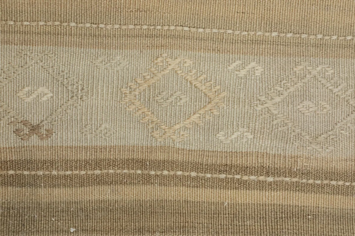 Detailed view of the central geometric motifs within the striped sections of the rug