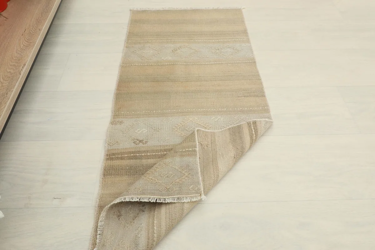Overhead view with one end of the rug gently folded, showing its thickness