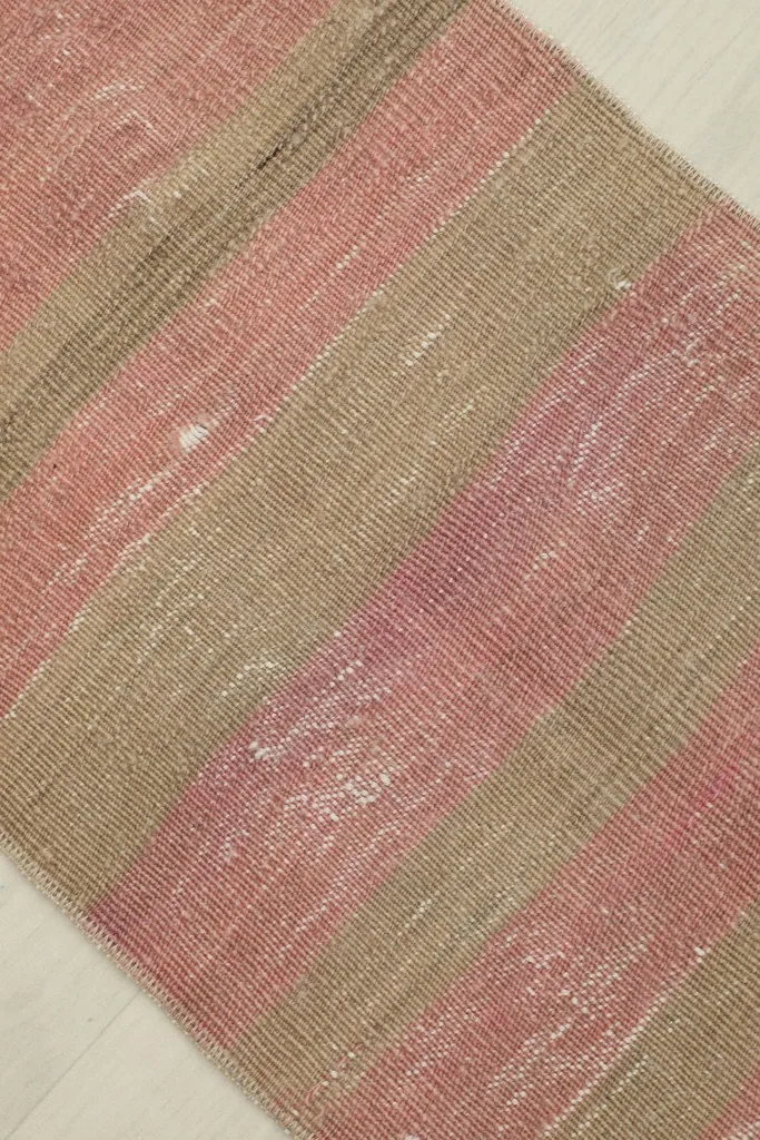 Diagonal close-up showing the subtle wear and texture variations within the striped wool pile.