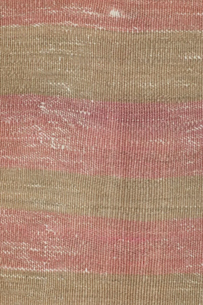 Overhead close-up of the rug's low wool pile, revealing the hand-knotted texture and color shifts.