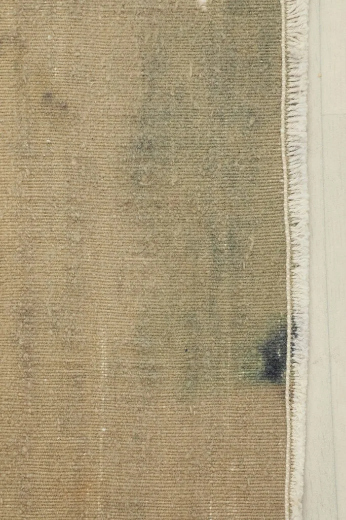 Close-up detail of the vintage wool pile and cotton foundation, showing texture and color variations