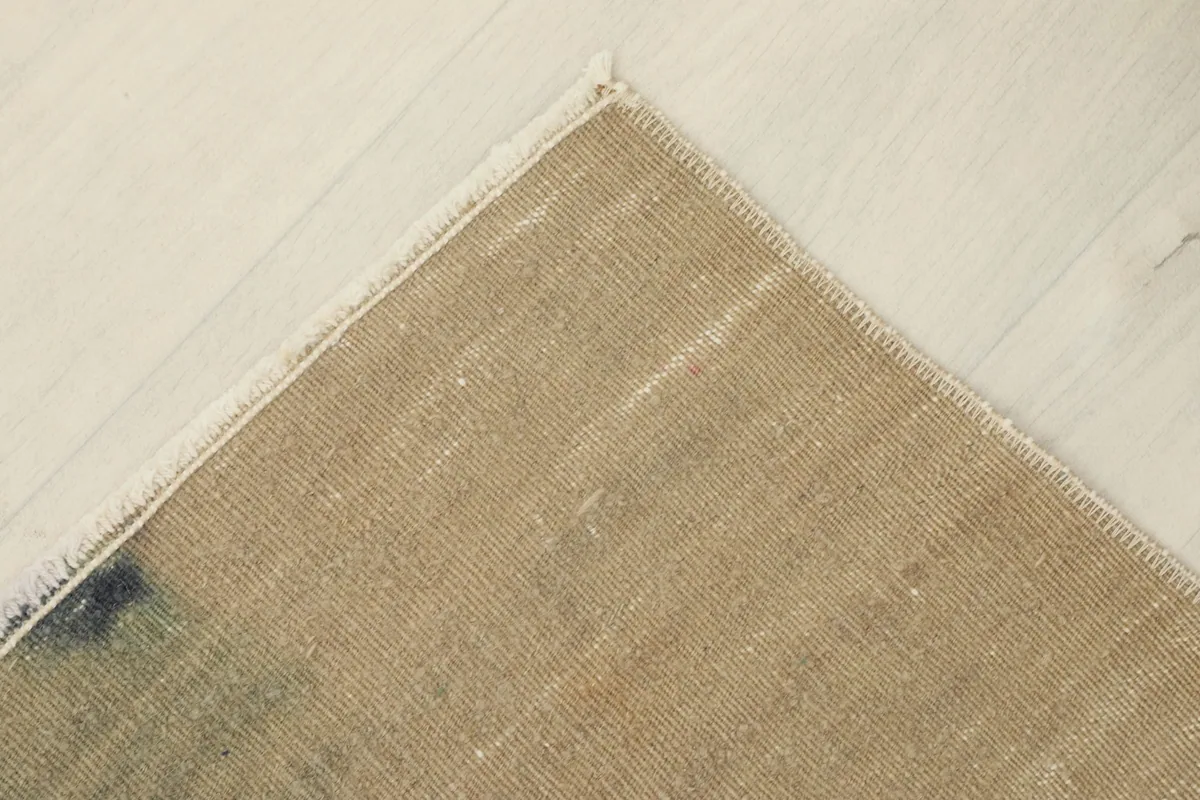 Corner view of the rug's back, revealing the cotton foundation and hand-knotted structure
