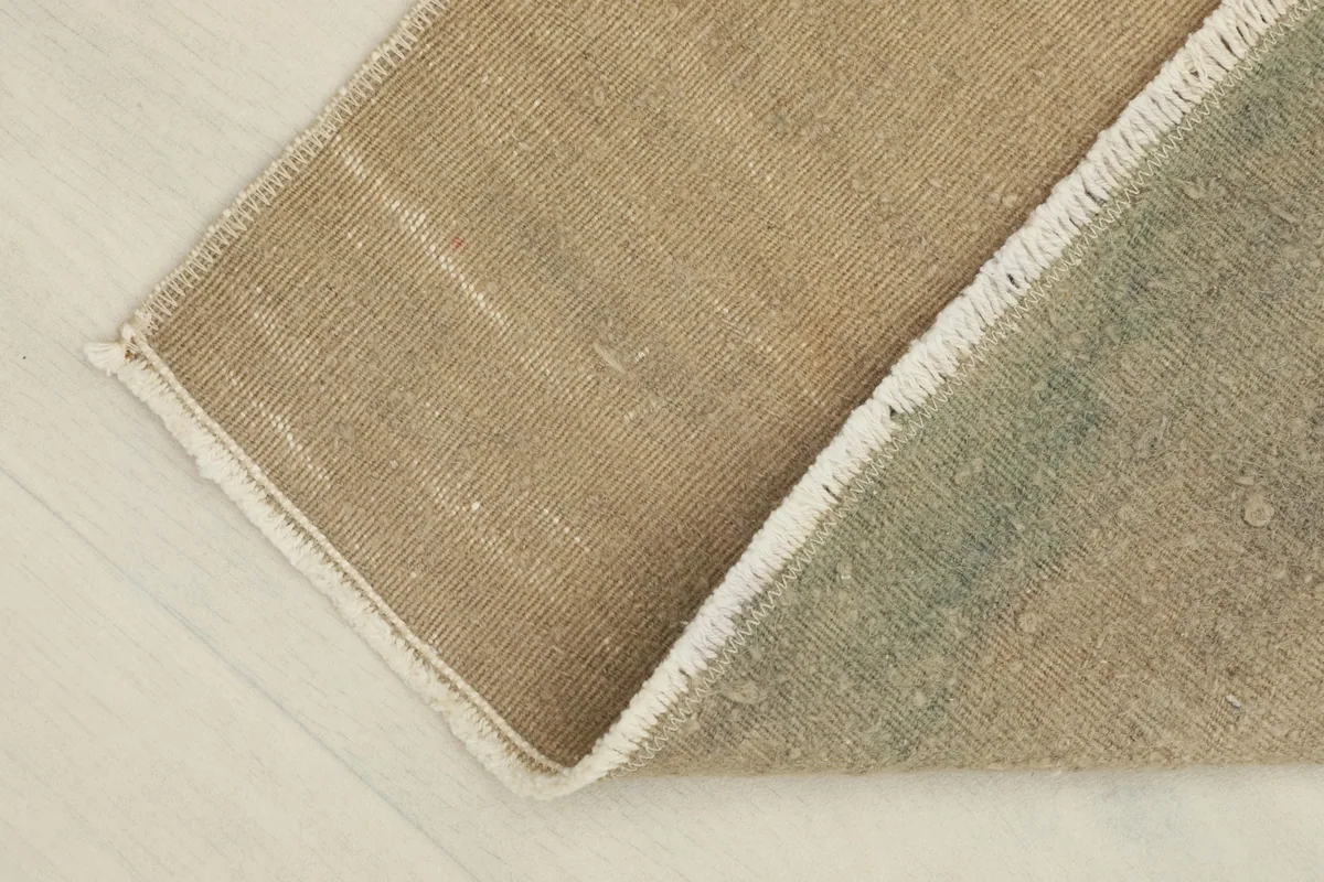 View of the rug folded to show the thickness and flexibility of the vintage wool material