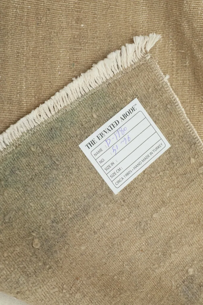 Close-up of the rug's label, confirming its origin, material, and vintage nature