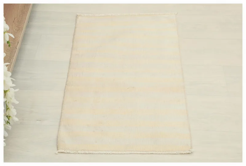 Full top view of the 1'6" x 2'6" ivory and beige striped vintage Anatolian rug on a white background.